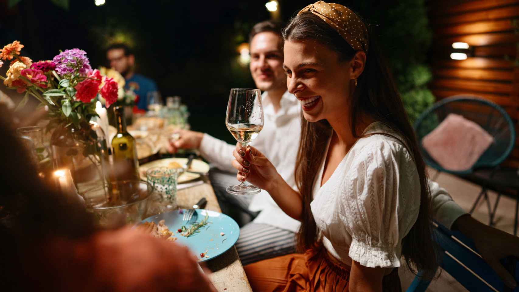 Imagen de archivo de una mujer disfrutando de una cena con sus amigos.