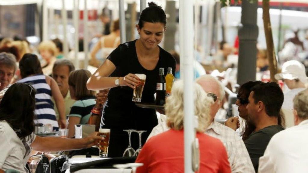 Una camarera sirve una mesa.