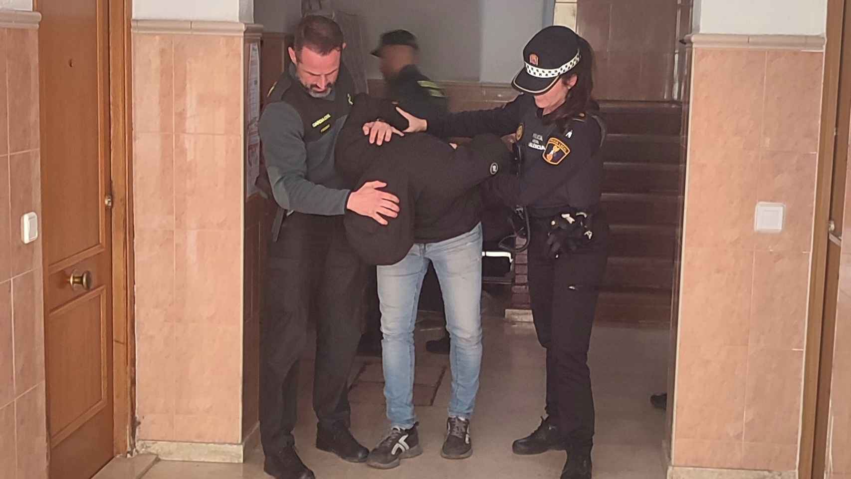 Imagen del detenido, junto a agentes de la Guardia Civil y la Policía Local de Valencia. EE