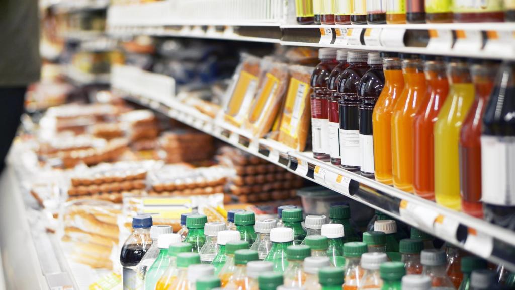 Un estante lleno de bebidas y refrescos en un supermercado.