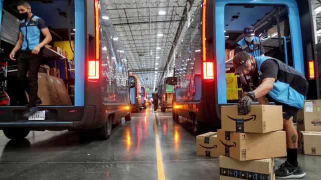 Trabajadores de Amazon cargando varias furgonetas de reparto de la compañía en Poway, California (Estados Unidos)