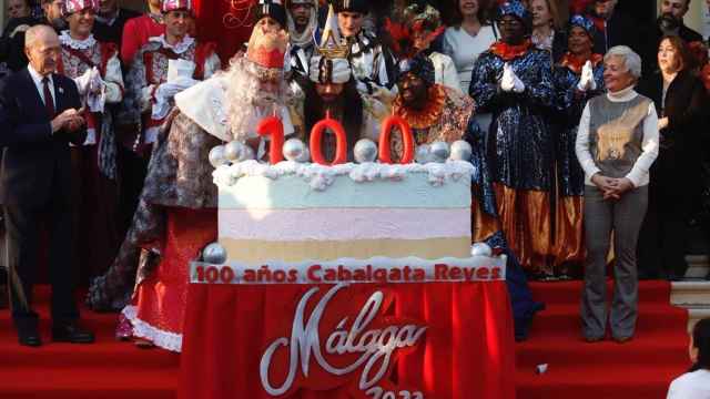 Los Reyes Magos de Oriente soplan las velas de una gran tarta por el centenario de la cabalgata de Málaga capital..