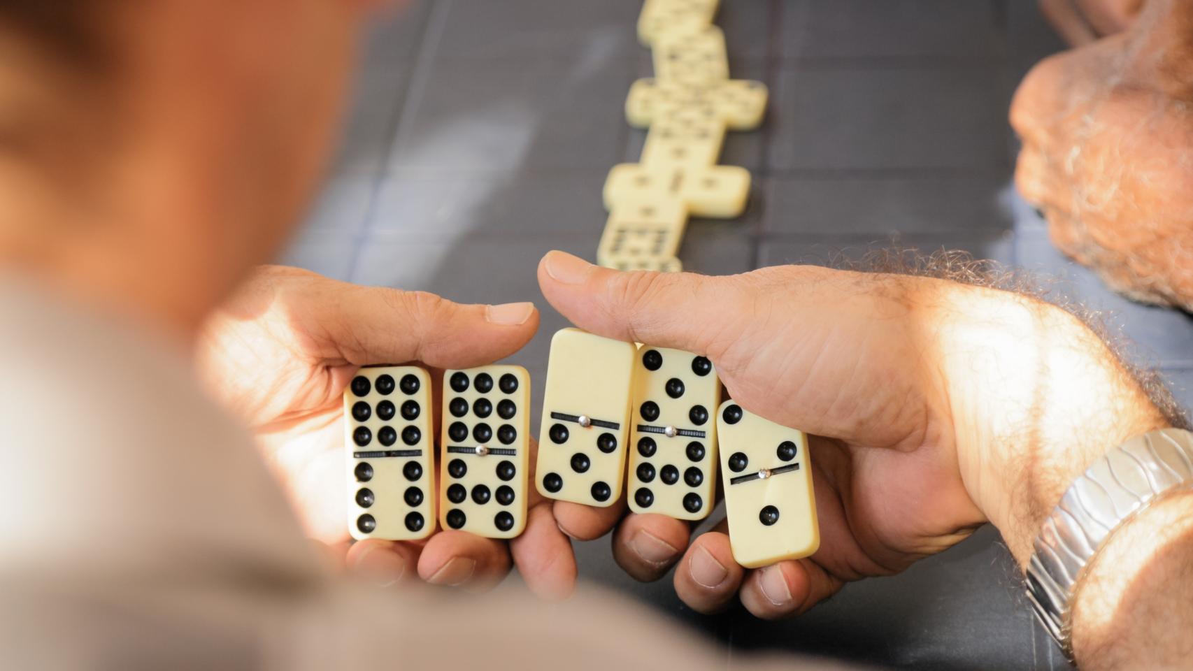 Una persone juega una partida de dominó en una imagen de archivo.