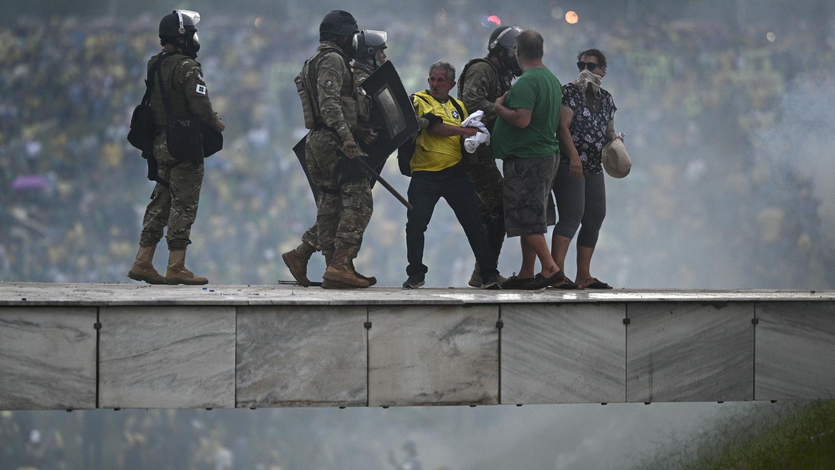 Policías se enfrentan a seguidores del expresidente brasileño Jair Bolsonaro.