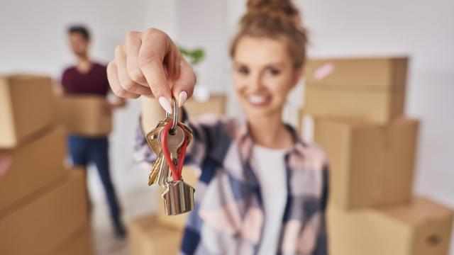 Una joven con las llaves de su nueva vivienda.
