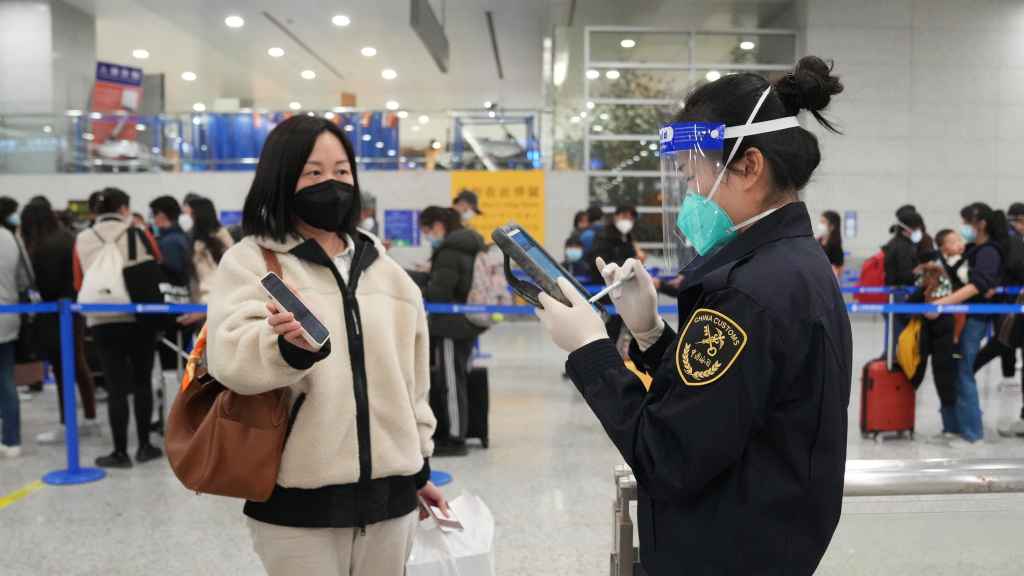 Un miembro del personal de la aduana del Aeropuerto de Shangha verifica la información de un pasajero.