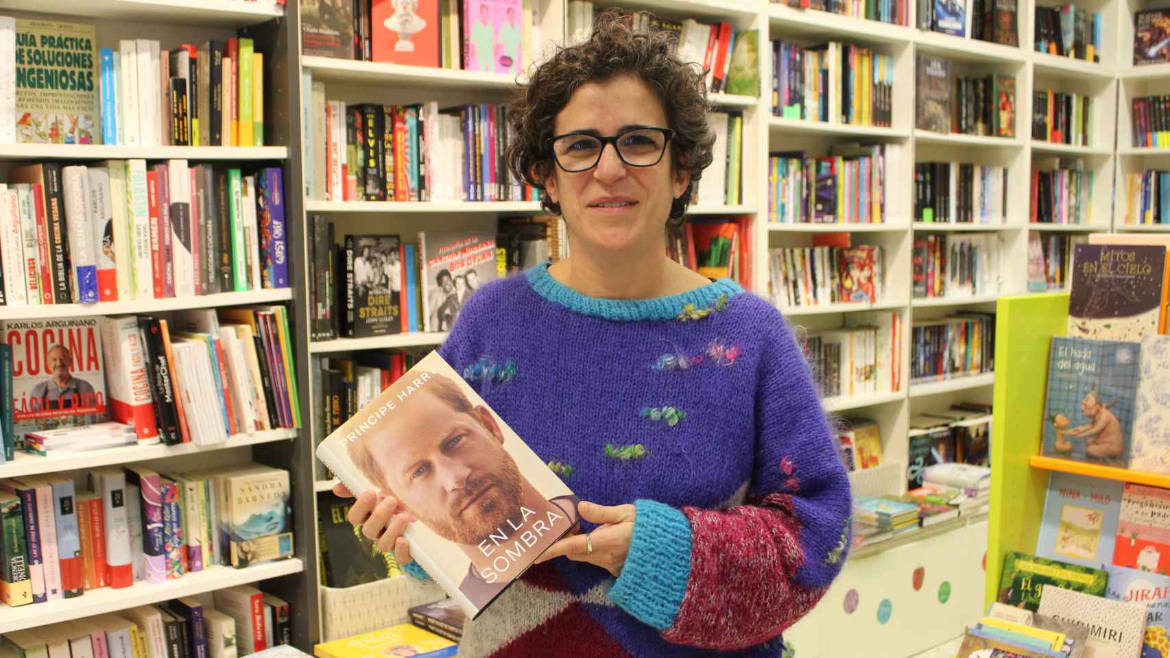 La librera Rocío Valverde, en su tienda, sujetando el libro de 'En la sombra' adquirido por EL ESPAÑOL.