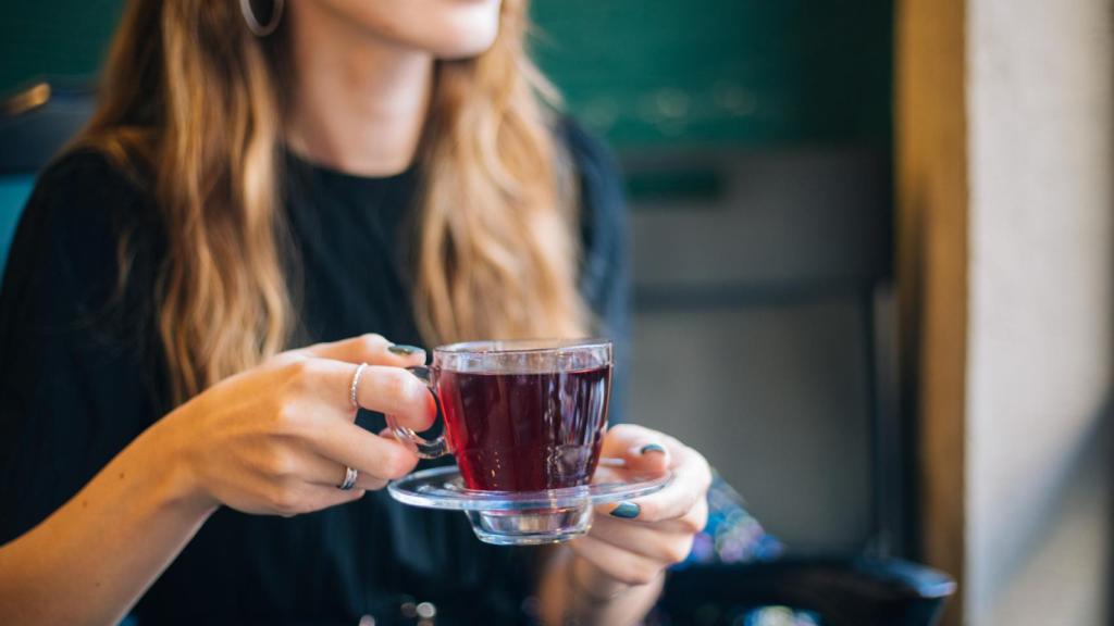 Una mujer, tomando una infusión.