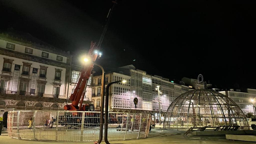 Operarios desmontan la gran bola de Navidad en La Marina de A Coruña.