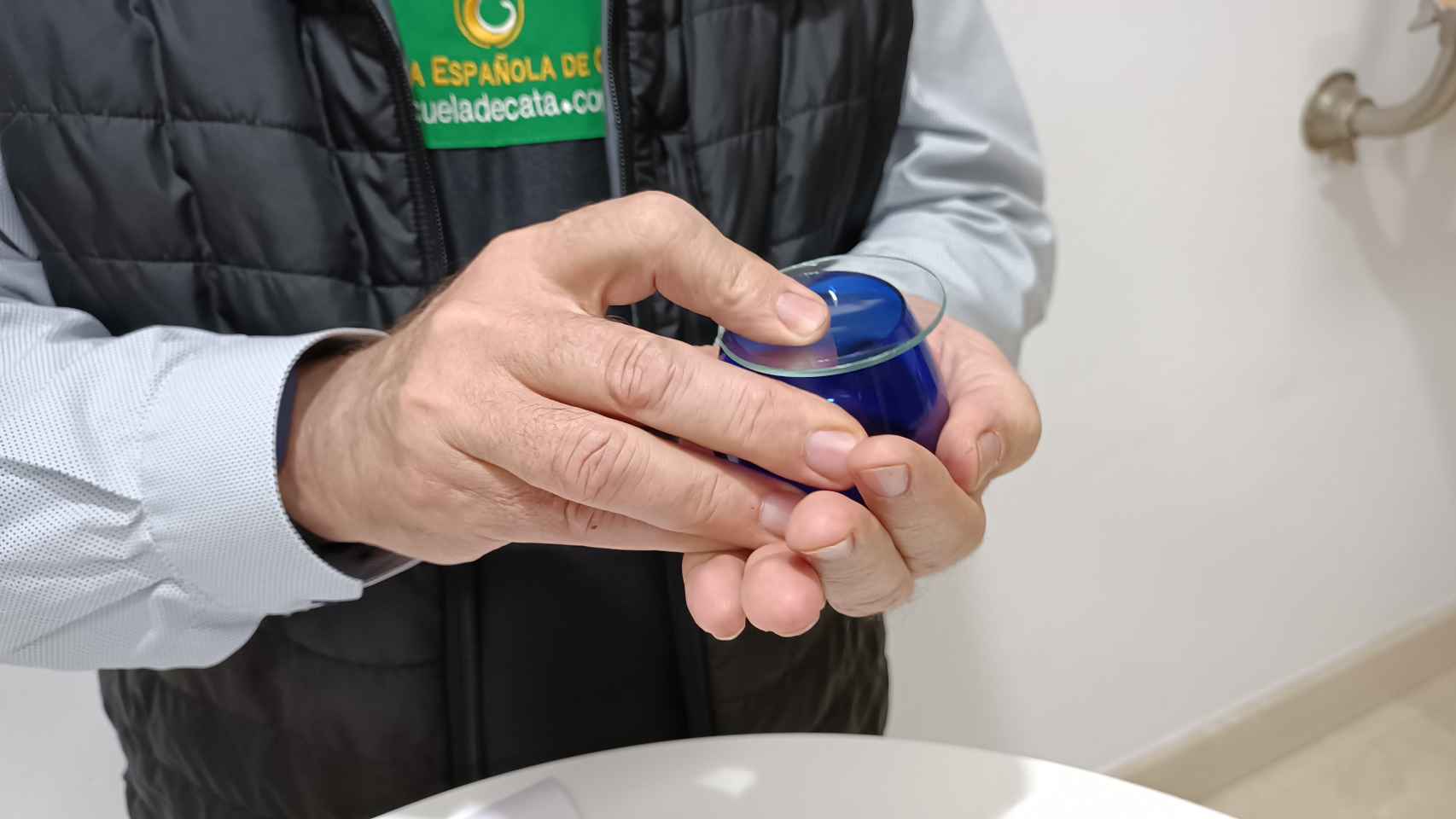 Carlos Gómez usa sus manos para calentar el vaso y, en consecuencia, el aceite.