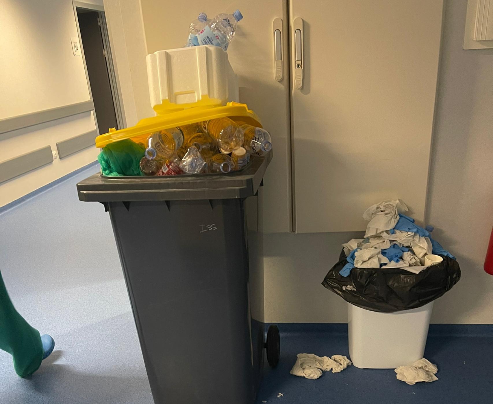 Cubos de basura y papeleras repletas en uno de los pasillos del hospital.