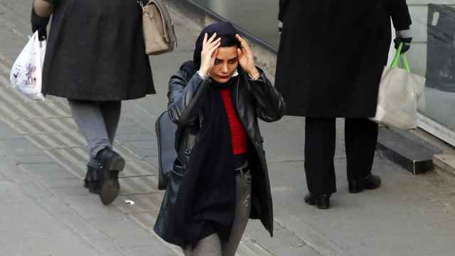 Una mujer se coloca el pañuelo mientras pasea por Teherán