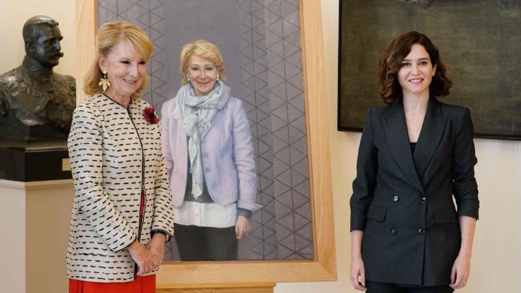 La expresidenta madrileña Esperanza Aguirre posa junto a su cuadro en la Asamblea con la actual mandataria, Isabel Díaz Ayuso. EE