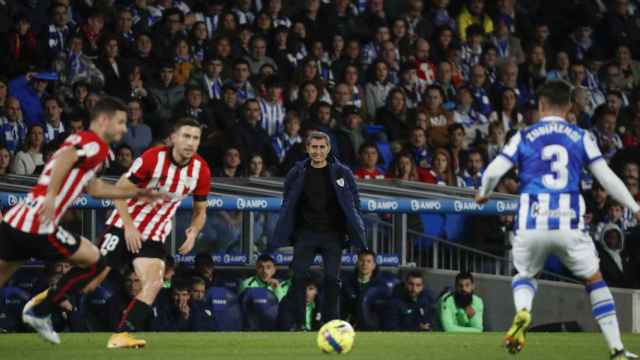 Ernesto Valverde, al fondo mientras jugadores de la Real Sociedad y el Athletic disputan un balón dividido.