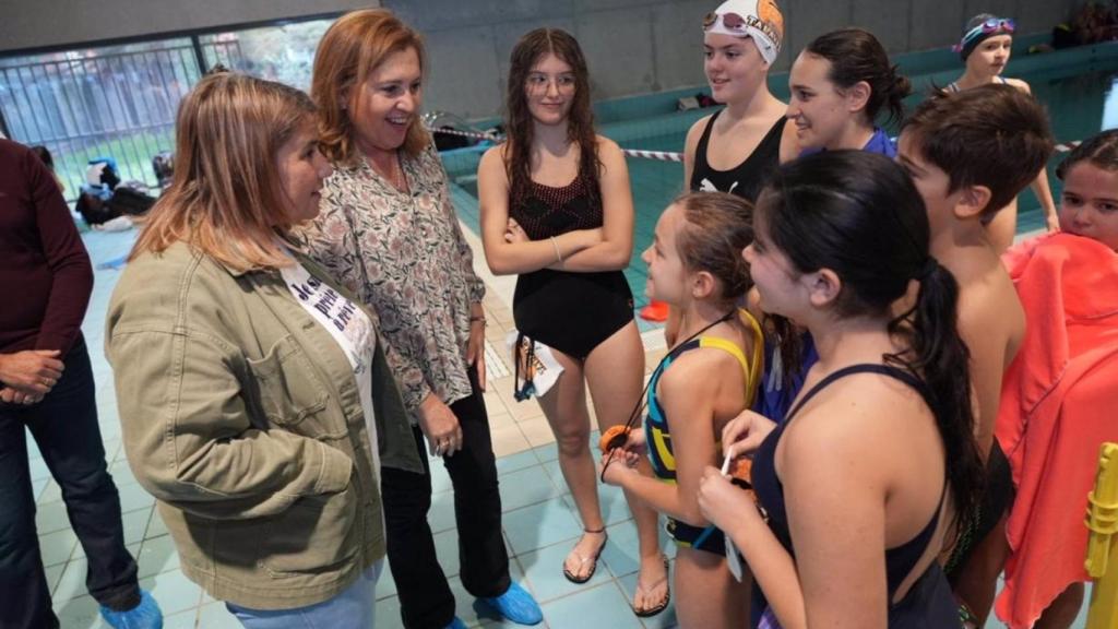 Rosa Ana Rodríguez y Tita García Élez en una prueba de natación para niños en edad escolar.
