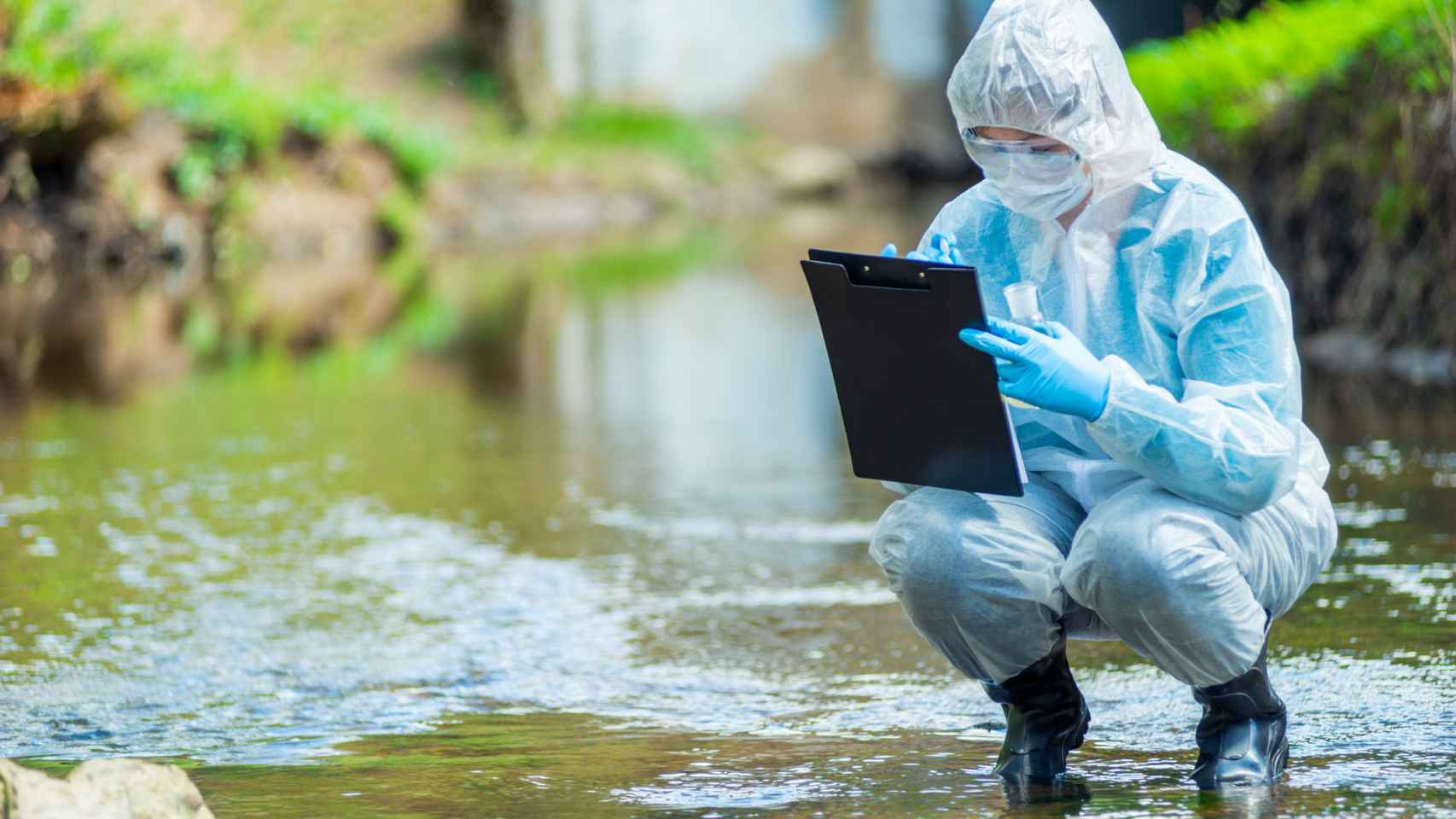 Un científico realiza pruebas químicas en un río.