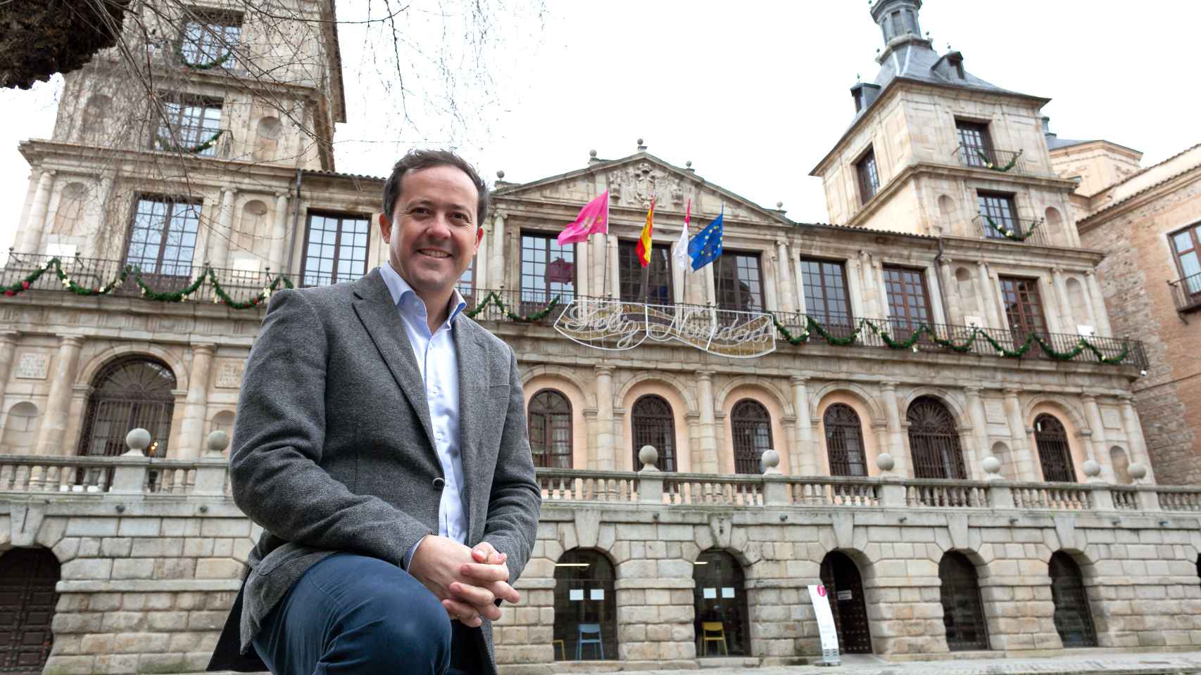 Carlos Velázquez posa frente a la fachada del Ayuntamiento de Toledo.