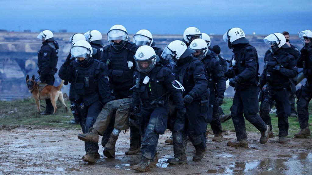 Un grupo de policías intentan desalojar a los manifestantes, pero se quedan atrapados en el barro.