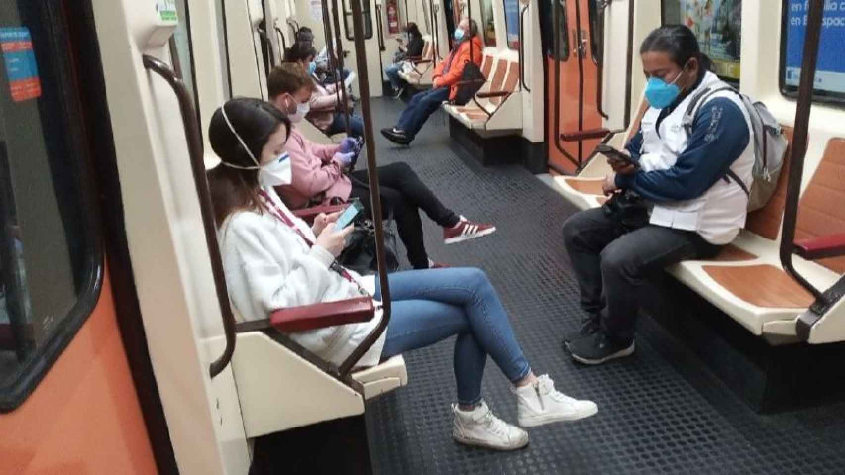 Varias personas con la mascarilla en el interior de un vagón del metro de Madrid.