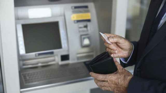 Un pensionista saca dinero de un cajero automático.