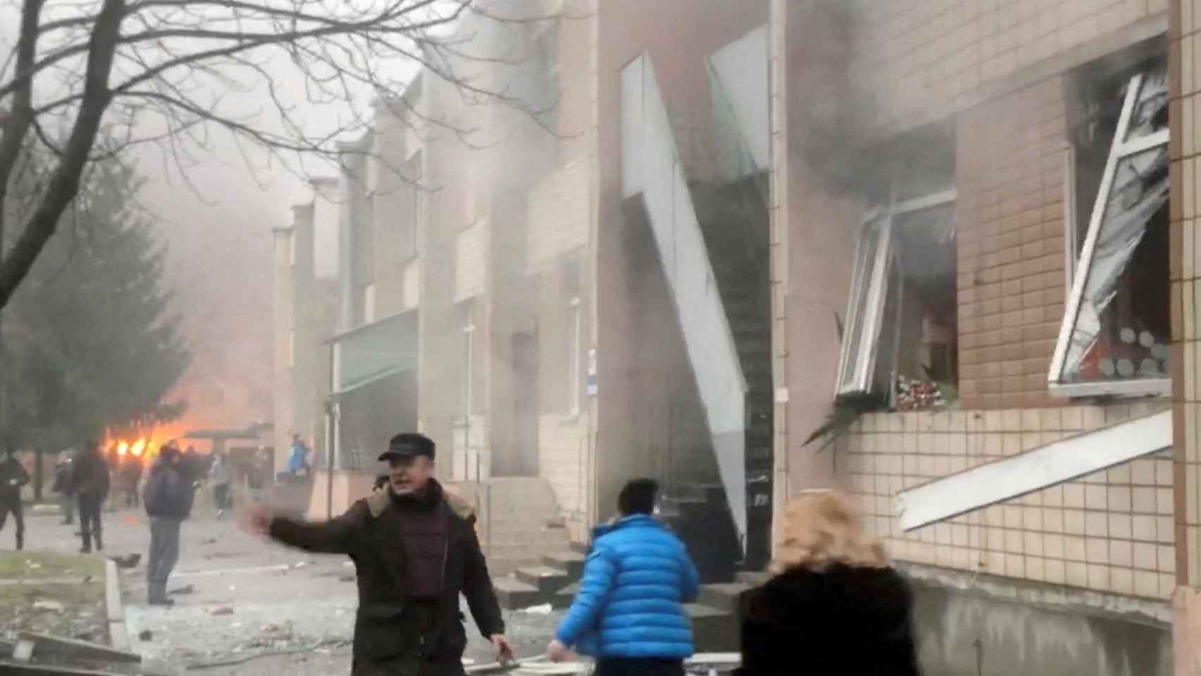 Personas corriendo por un edificio momentos después de que un helicóptero se estrellara contra él, en Brovary, Kiev, Ucrania , el 18 de enero de 2023.