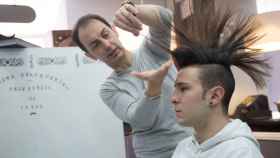 José Pérez con uno de sus clientes en su peluquería.