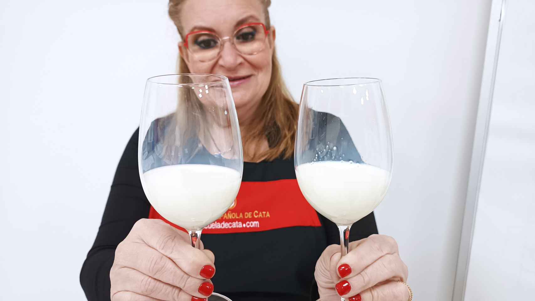 Carmen Garrobo muestra cómo la leche de Carrefour, en comparación con la de Dia, deja grumos de grasa.