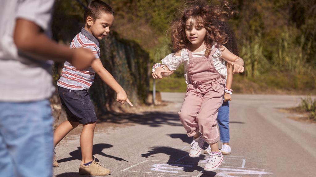 Foto de archivo de niños jugando en la calle.