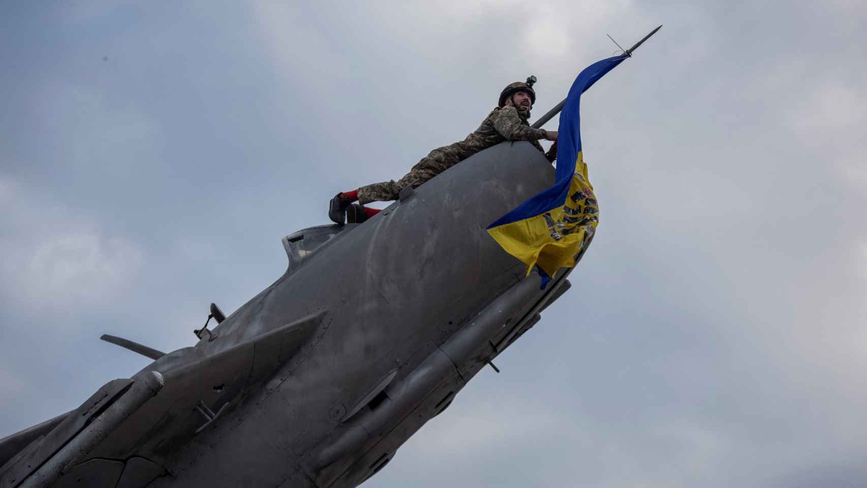Un militar ucraniano instala una bandera nacional en un avión de combate en monumento en Bajmut.