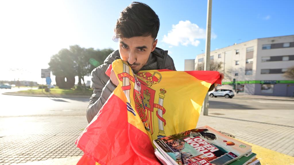 Musta, con el temario de la Guardia Civil mientras besa una bandera de España.