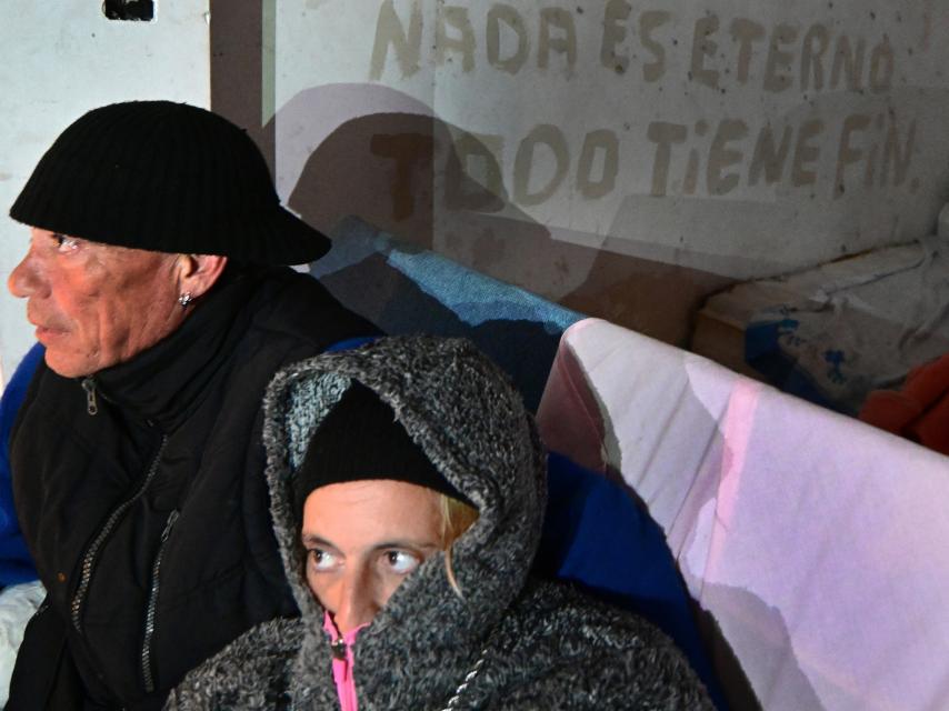 Puri se resguarda del frío. Al fondo, la pintada junto al colchón donde duermen.