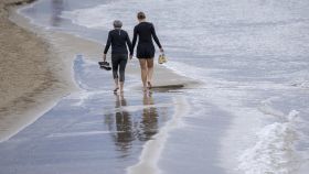 Dos personas caminan por una playa valenciana a principios de enero.