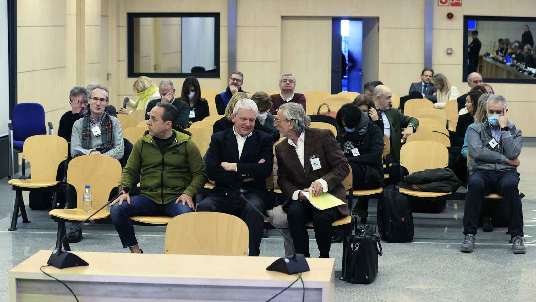 Los acusados escuchan al tribunal al inicio del juicio.