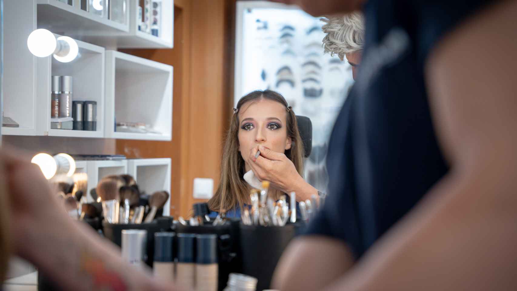 El maquillador Javier Díez perfila los labios de la periodista Paloma Garrido.