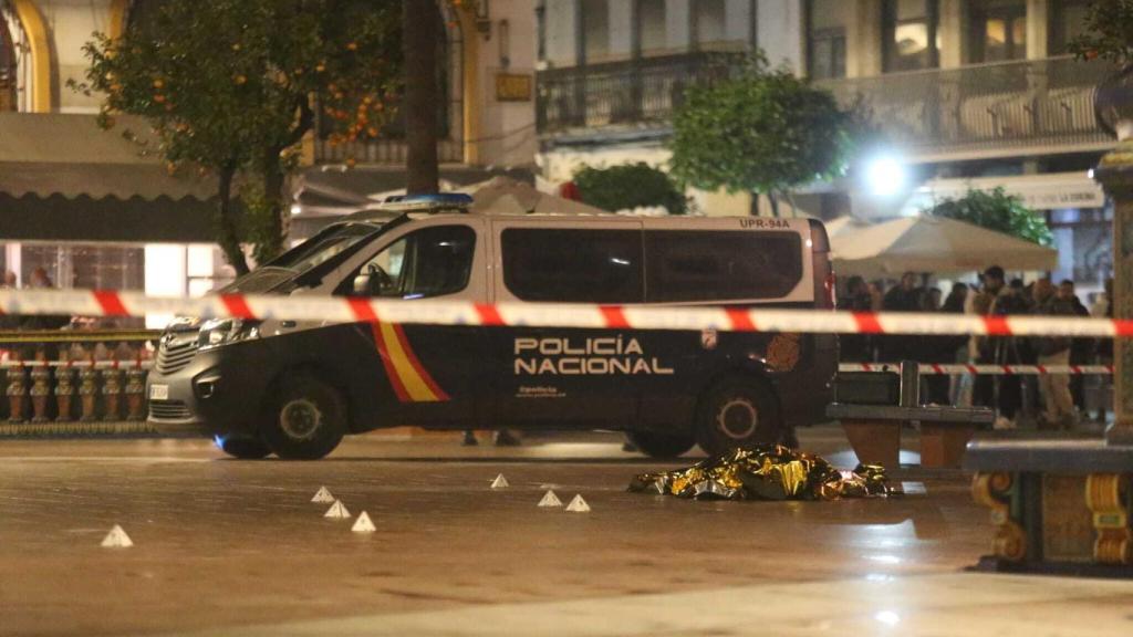 Efectivos policiales y sanitarios cubren el cadáver del cura apuñalado.