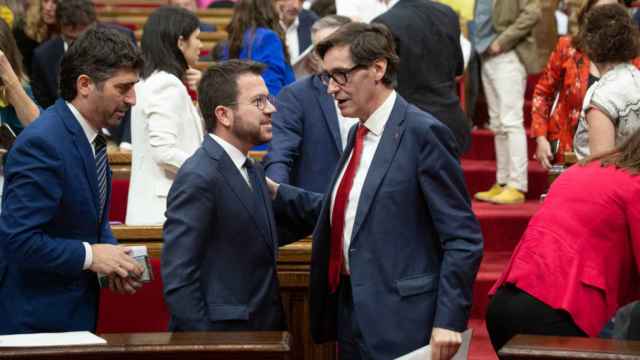 El presidente de la Generalitat, Pere Aragonès, y el líder del PSC, Salvador Illa, conversando tras aprobar una la ley en el Parlament el pasado 8 de junio de 2022.