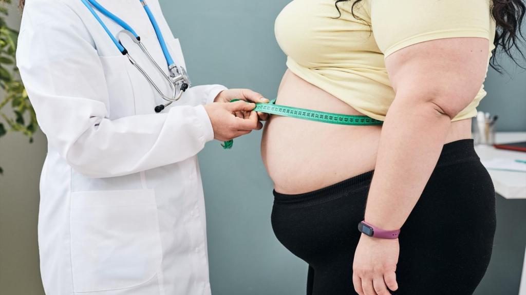 Médica midiendo el contorno a una persona obesa