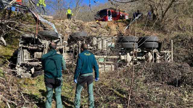 Agentes y servicios de emergencias en la zona donde se precipitó el vehículo.