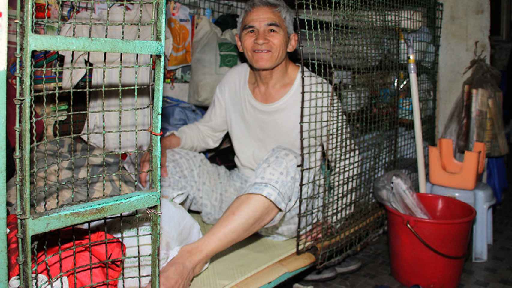 Un hombre en una casa-jaula de Hong Kong