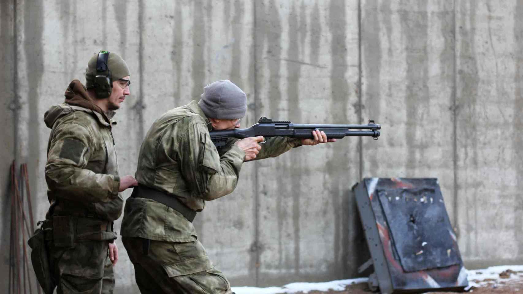 A la izquierda, Gariyev coordinando las prácticas de tiro de un voluntario de la Legión Imperial.