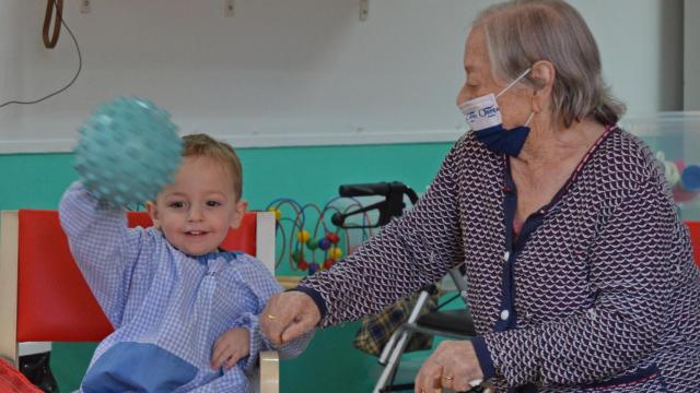 El pequeño Oliver y la anciana Calixta juegan con una pelota en una de las actividades propuestas en la Residencia Orpea  de Meco.