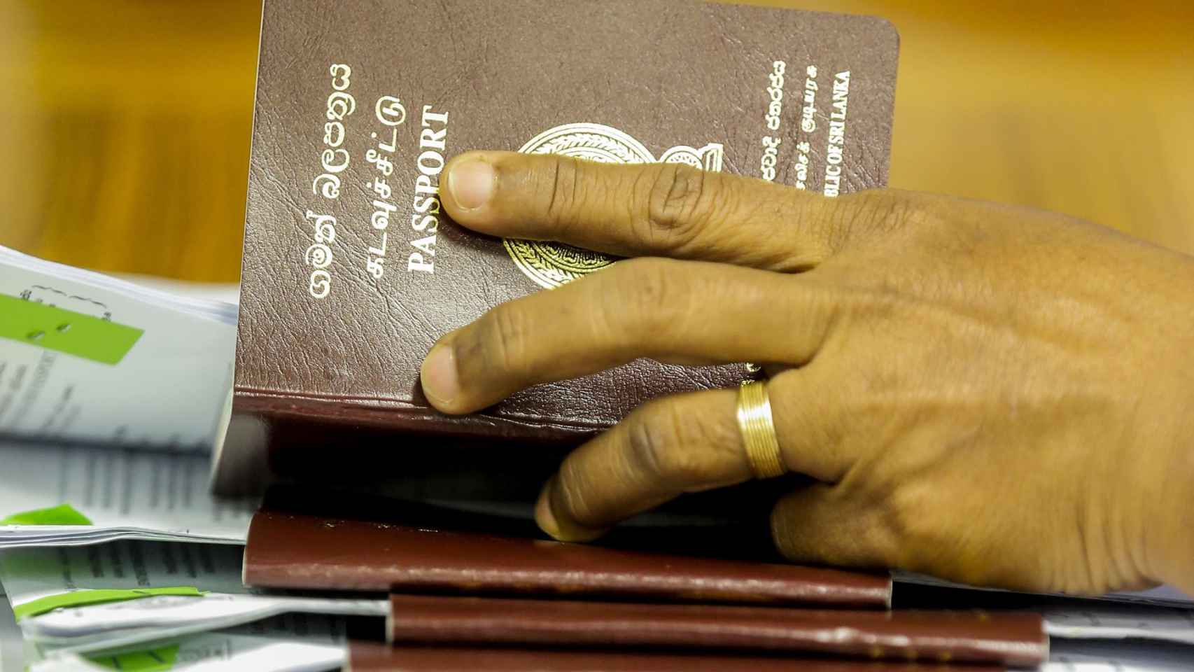 Un funcionario revisando pasaportes en el Departamento de Inmigración y Emigración