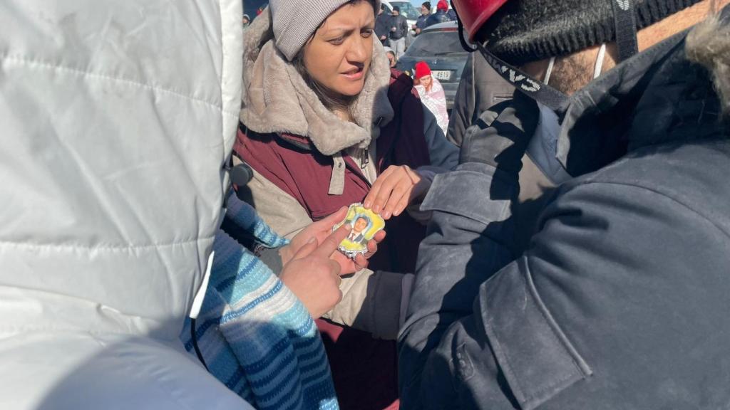 Una mujer sostiene la foto de su hijo después de que un rescatista se la entregase tras encontrarla entre las ruinas de un edificio en Gaziantep.