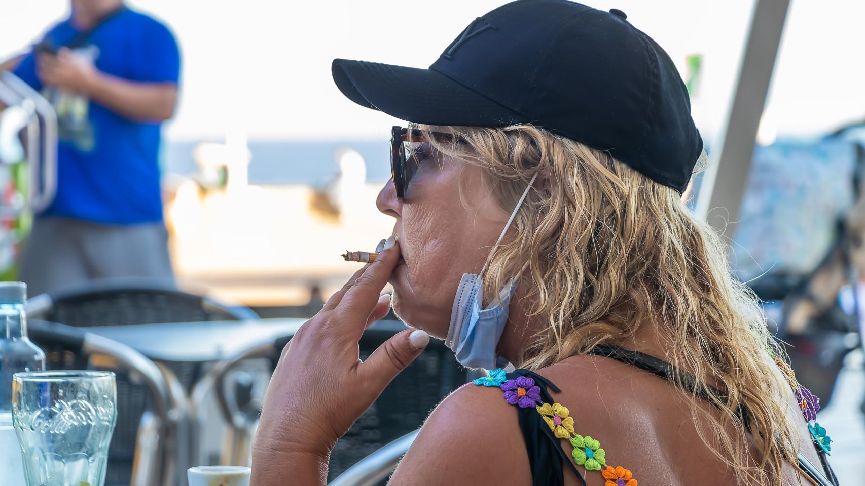 Una mujer se fuma un cigarro en la terraza de un bar, en una imagen de archivo.