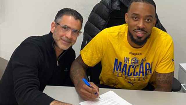 Lorenzo Brown firmando una renovación de contrato con Maccabi