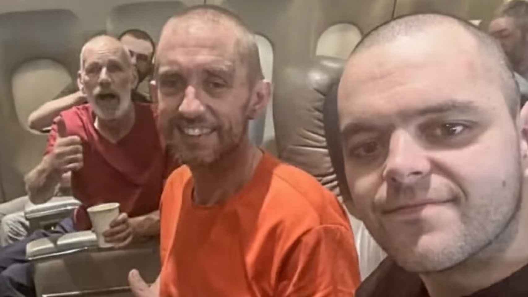 De izquierda a derecha, John Harding, Shaun Pinner y Aiden Aslin, en el avión, tras su liberación, de vuelto al Reino Unido.