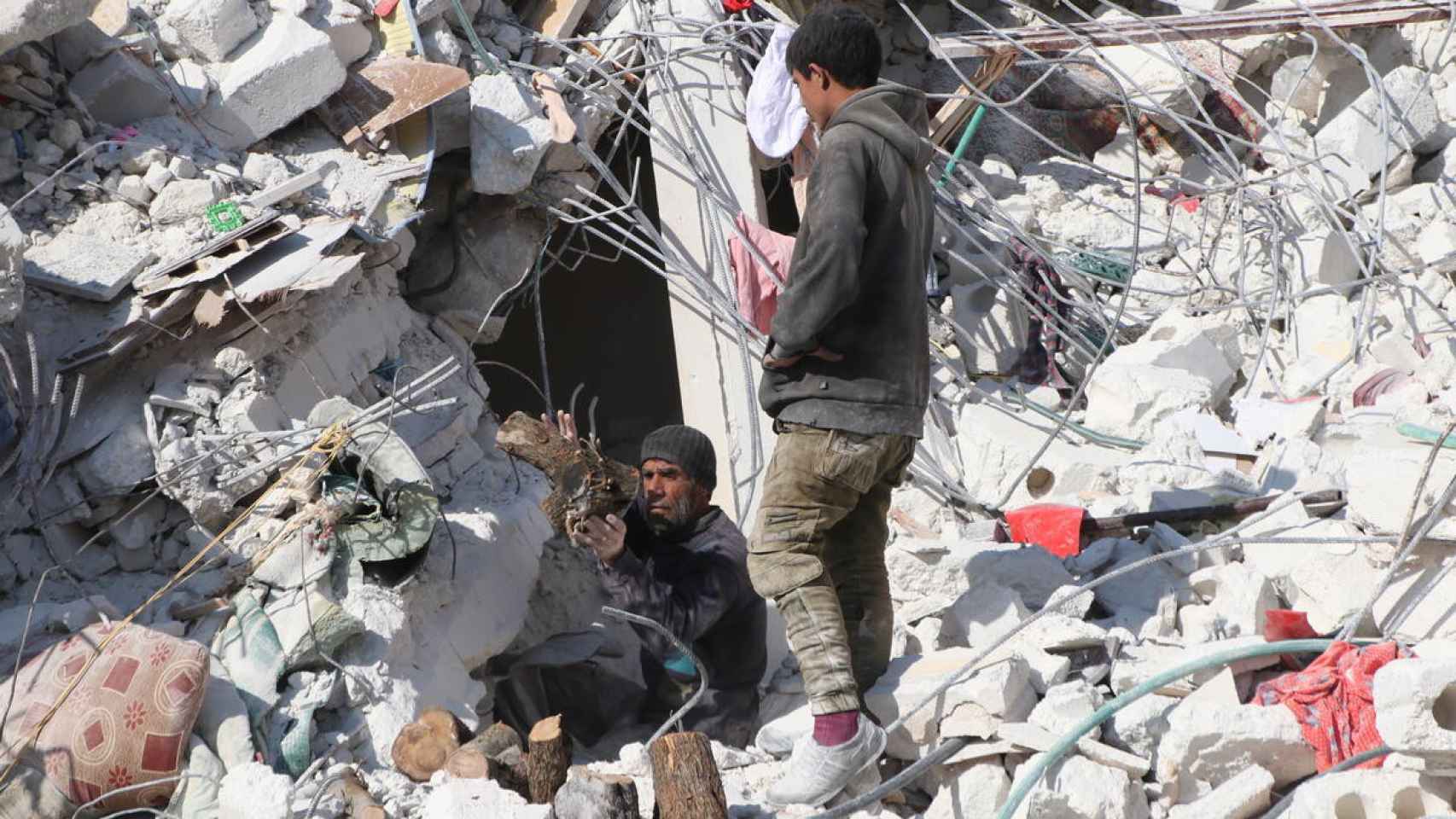 Un hombre y un niño rebuscando entre los escombros tras el terremoto