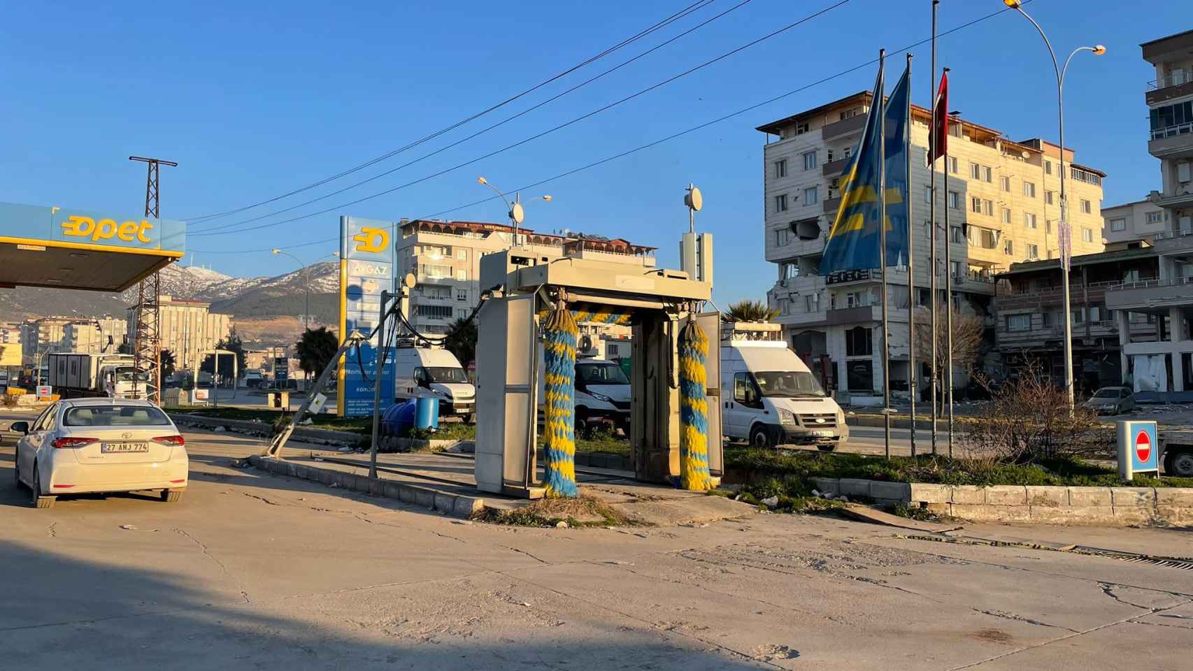 Gasolinera en la que trabaja Serhat, donde pueden verse tres furgonetas con antenas móviles portátiles en medio de la destrucción provocada por el terremoto.