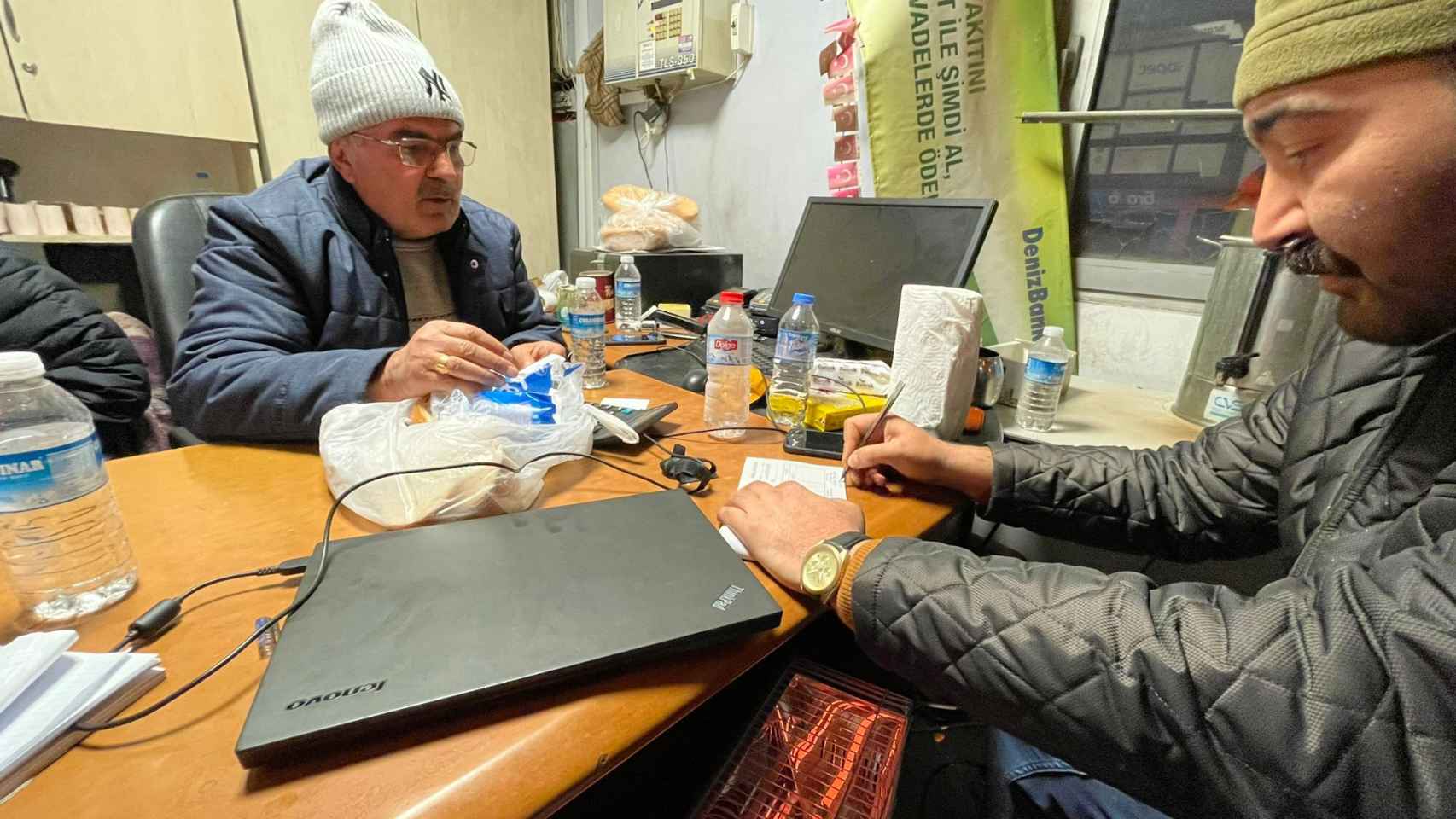 Serhat (derecha) en la garita de su gasolinera junto a un empleado.