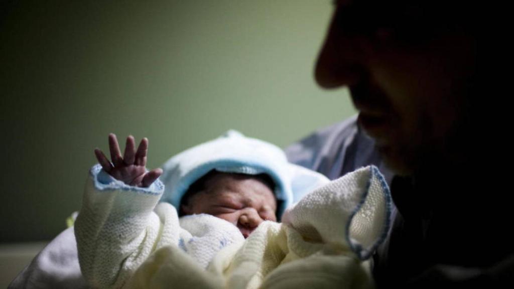 Una foto de un bebé con su padre, en imagen de archivo.